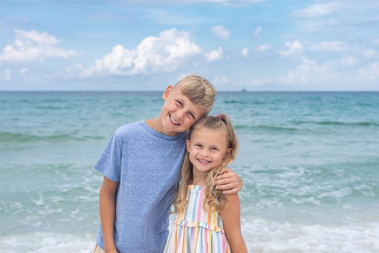 Casual beach family photos with ocean waves and blue sky in the background