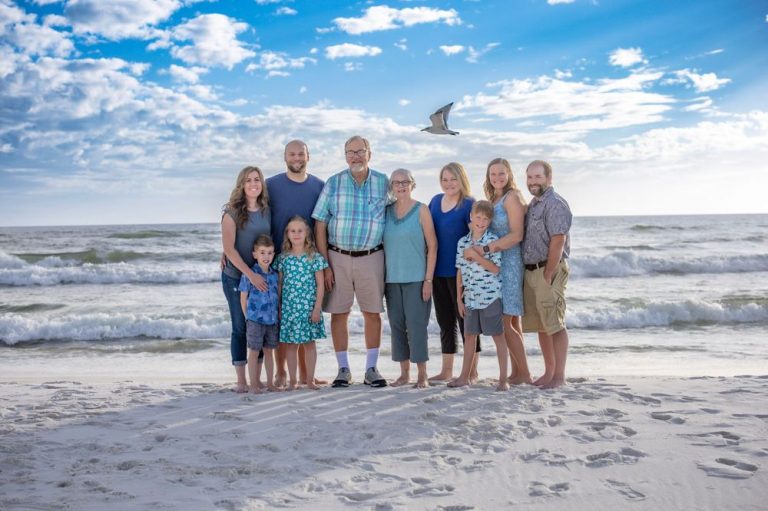 Family group photo session on a sunny beach with white sand and blue ocean waves