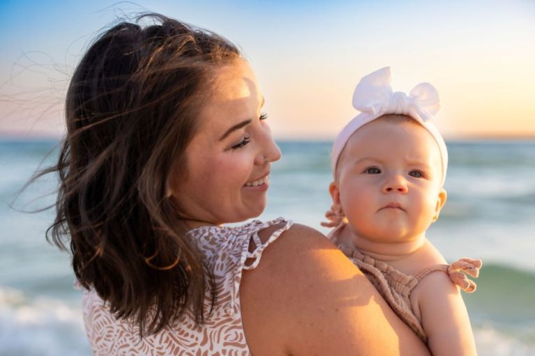 Mother and baby sharing tender moment at sunset on beach